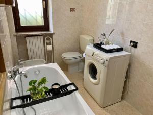 a bathroom with a washing machine and a bath tub at Appartamento indipendente a Mirafiori Sud in Turin