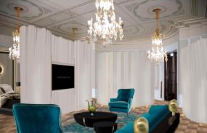 a living room with blue chairs and a chandelier at NH Collection Helsinki Grand Hansa in Helsinki