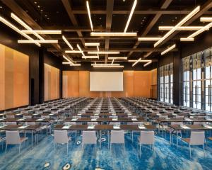 an empty hall with tables and chairs and a screen at Hyatt Centric Lakeside Ningbo in Ningbo