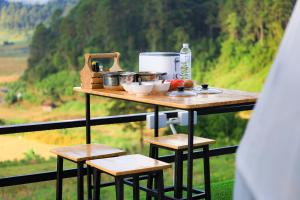 - une table avec des casseroles et des poêles au-dessus du balcon dans l'établissement สวนไร่รุ่งอรุณ, à Ban Na Pa Paek