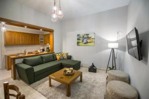 a living room with a green couch and a table at Trikala Home in Tríkala