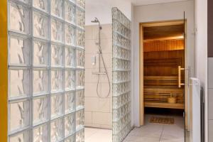 a shower in a bathroom with a glass wall at Vienna House Easy by Wyndham Osnabrück in Osnabrück