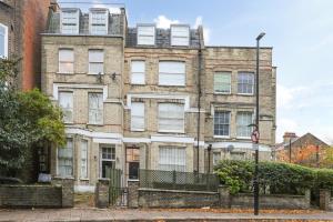 an old brick building with windows on a street at Studio Flat West End Lane in London