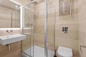 a bathroom with a shower and a sink and a toilet at Studio Flat West End Lane in London