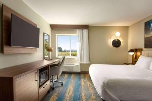 コロンビアにあるLa Quinta Inn by Wyndham Columbia NE Fort Jacksonのベッドと机とテレビがあるホテルの部屋