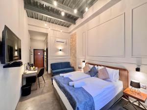 a bedroom with a large bed and a blue couch at Bazaar Boutique Residence in Budapest