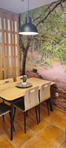 a dining room table with chairs and a painting on the wall at Apartamento Cobre in Riópar
