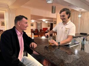 Royal Swan, Ashley Manor - Bed and Breakfast في سيدفيلد: اثنين من الرجال واقفين في حانة مع الشراب