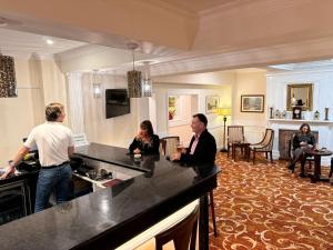 a group of people sitting at a counter in a kitchen at Royal Swan, Ashley Manor - Bed and Breakfast in Shedfield