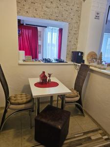 a small table with two chairs and a table with a red plate at Anastasia Crib in Craiova