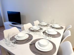 a table with white plates and wine glasses on it at Aurora City Suite in Rovaniemi