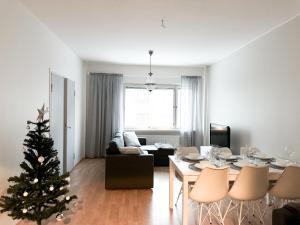 a living room with a christmas tree and a table at Aurora City Suite in Rovaniemi