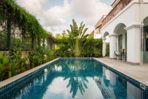 a swimming pool in front of a house at La Mosteiro in Assagao, Splendid 3&4BHk Villas with Private Pool, Private Parking, Garden, Caretaker, Kitchen & Security in Vagator