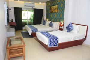 Habitación de hotel con 2 camas y mesa en Hotel Shiv International en Bhachāu