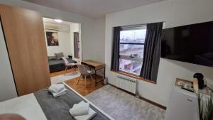 a living room with a large window and a desk at Olimpus Apartmani BD Banjaluka in Banja Luka
