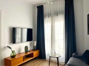 uma sala de estar com uma televisão e uma janela em Apartamento San Juan, Parking privado em Jerez de la Frontera
