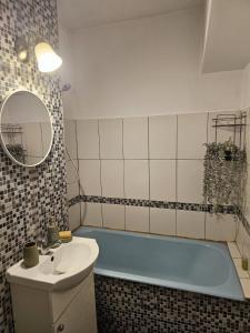 a bathroom with a blue tub and a sink at Anastasia Crib in Craiova