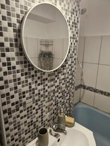 a bathroom with a sink with a mirror and a tub at Anastasia Crib in Craiova