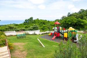 a playground with a play equipment in a yard at Ms. T's Paradise @ Pyramid Point in Ocho Rios