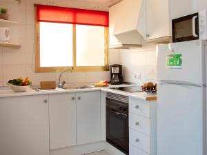 een keuken met witte kasten en een witte koelkast bij Studio Apolo VI-4 by Interhome in Calpe