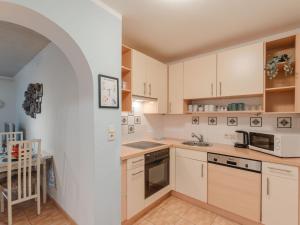 - une cuisine avec des placards blancs et un évier dans l'établissement Apartment Rudis Appartements-1 by Interhome, à Badbruck