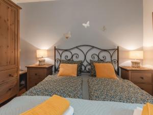 - une chambre dotée d'un lit avec des oreillers orange dans l'établissement Apartment Rudis Appartements-1 by Interhome, à Badbruck