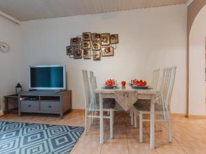 a dining room with a table and a tv at Apartment Terrace Garden Retreat by Interhome in Badbruck