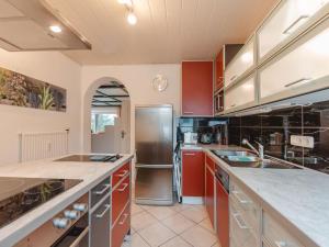 a kitchen with red cabinets and a stainless steel refrigerator at Apartment The Alpine Classic by Interhome in Badbruck +29 photos