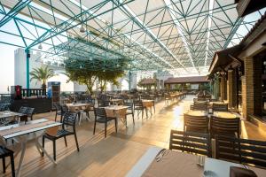 a restaurant with tables and chairs and a glass ceiling at Master Family Club in Manavgat