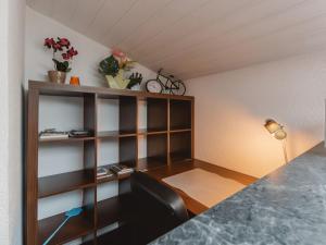 a room with a desk and a shelf with flowers at Apartment Rudis Appartements-4 by Interhome in Badbruck