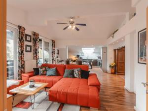 - un salon avec un canapé orange et une table dans l'établissement Apartment Rudis Appartements-4 by Interhome, à Badbruck