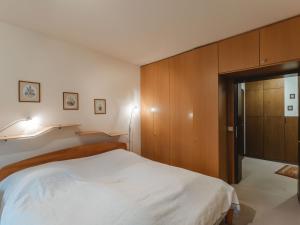 バート・ホーフガシュタインにあるApartment Sun & Mountain View by Interhomeの白いベッドと木製キャビネット付きのベッドルーム1室