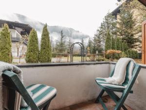 two chairs on a balcony with a view of a house at Holiday Home Keil by Interhome in Bad Gastein