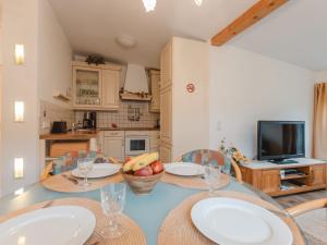 a kitchen with a table and chairs and a television at Holiday Home Keil by Interhome in Bad Gastein +27 photos