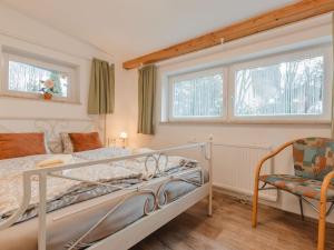a bedroom with a bed and a chair and windows at Holiday Home Keil by Interhome in Bad Gastein