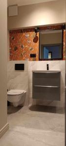 a bathroom with a sink and a toilet and a mirror at Triton Park Apartments in Warsaw