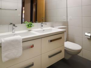 a bathroom with a sink and a toilet at Apartment Allod Park Haus C 206 by Interhome in Davos