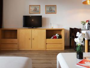 ein Wohnzimmer mit einem TV auf einem Holzschrank in der Unterkunft Apartment Allod-Park-6 by Interhome in Davos