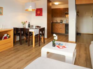 ein Wohnzimmer und eine Küche mit einem Tisch und Stühlen in der Unterkunft Apartment Allod-Park-6 by Interhome in Davos