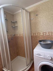 eine Dusche mit Waschbecken und Waschmaschine im Badezimmer in der Unterkunft Orsalia's Apartment in Neapolis + 22 Fotos
