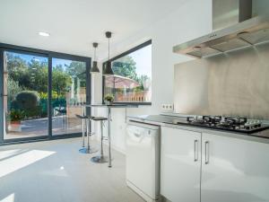 a kitchen with white appliances and a large window at Holiday Home Can Bernat by Interhome in Biniamar