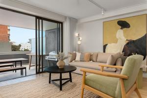 a living room with a couch and a painting at Suro Luxury Apartments in Cape Town