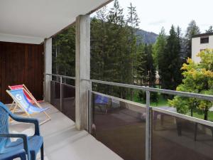 balcón con sillas y vistas a los árboles en Apartment Allod-Park-43 by Interhome en Davos