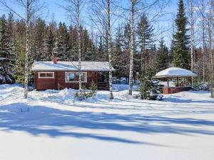 een blokhut in de sneeuw met een tuinhuisje bij Holiday Home Iltarusko by Interhome in Savonranta