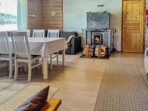 a dining room with a table and a fireplace at Holiday Home Iltarusko by Interhome in Savonranta
