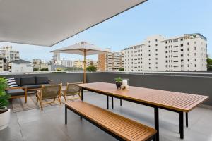a balcony with a table and chairs and an umbrella at Suro Luxury Apartments in Cape Town