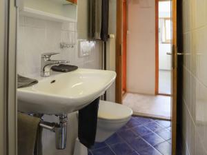 uma casa de banho com um lavatório branco e um WC. em Apartment Haus Chumma Apt1 by Interhome em Frauenkirch