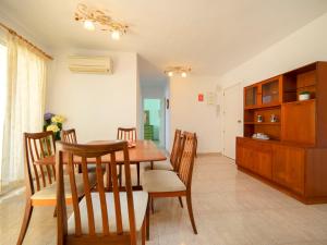 eine Küche und ein Esszimmer mit einem Holztisch und Stühlen in der Unterkunft Apartment Apolo IV-8 by Interhome in Calpe