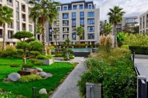 um complexo de apartamentos com um jardim e palmeiras em Exclusive St Constantine Suites em St. Constantine and Helena