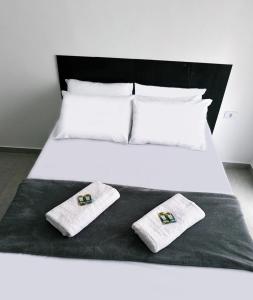 a bed with two towels on top of it at Hotel Village in São Bernardo do Campo